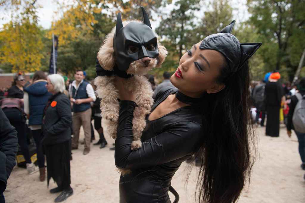 A woman dressed as Catwoman holds her dog dressed as Batman during the annual Tompkins Square Halloween dog parade in the Manhattan borough of New York October 24, 2015. REUTERS/Stephanie Keith